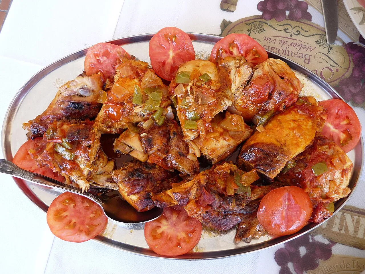Готовая курица с помидорами на блюде в Сан-Филипе