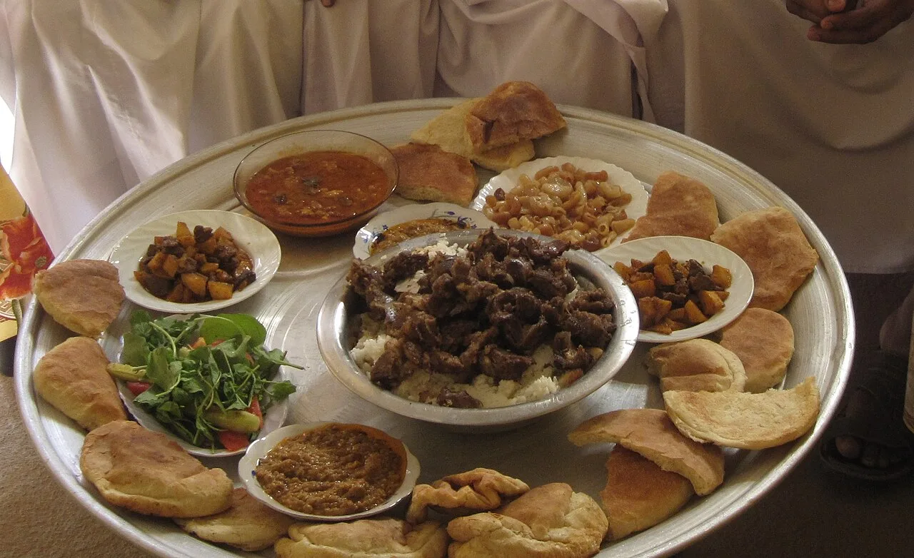 Велике блюдо з рисом, м’ясом, хлібом і закусками